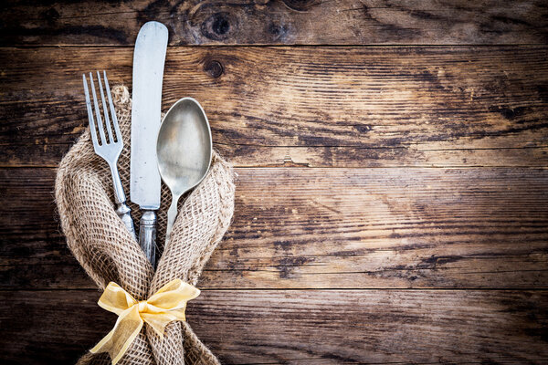 Старый нож, ложка и вилка декоративно представлены
.