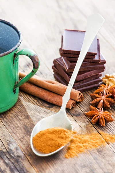 Chocolade houten tafel omgeven door specerijen. Rechtenvrije Stockfoto's