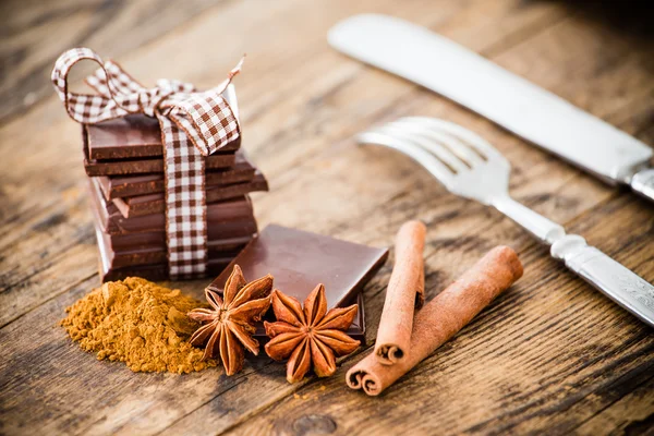 Mesa de madeira de chocolate cercada por especiarias . — Fotografia de Stock