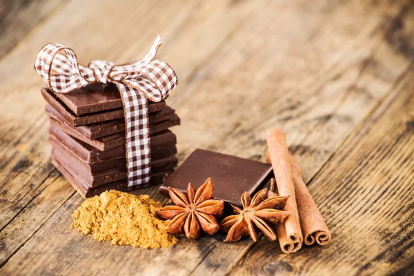 Choklad bord av trä omgiven av kryddor. — Stockfoto