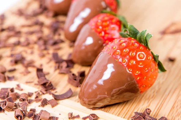 Çikolata batırılmış çilek, çikolata parçaları onun etrafında.