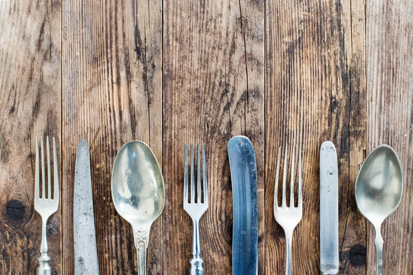 Cuchara cuchillo y tenedor en la tabla de madera . — Foto de Stock