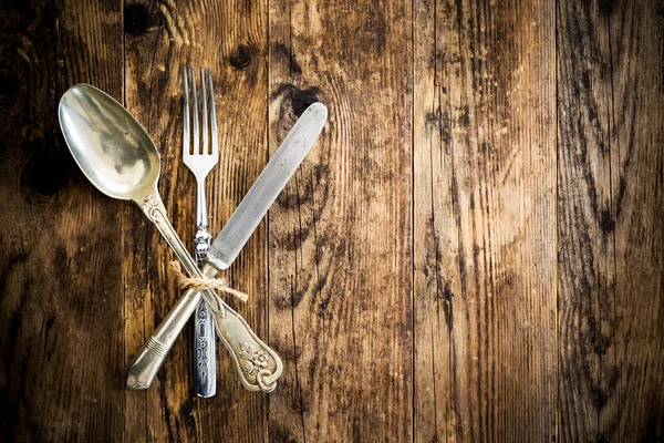 Cuchara cuchillo y tenedor en la tabla de madera . — Foto de Stock