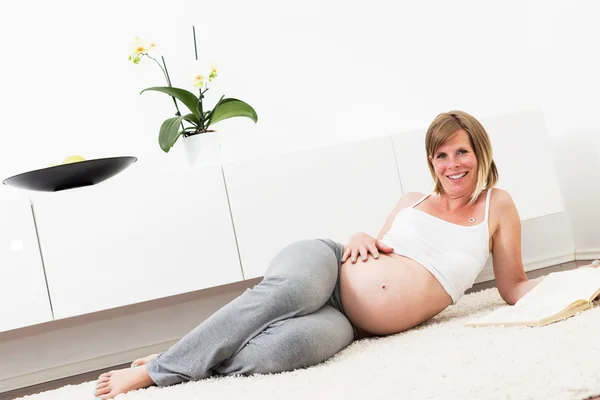 Mujer rubia embarazada en su casa . — Foto de Stock