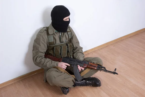 Terrorista Con Arma Kalashnikov Sentado Cerca Pared —  Fotos de Stock