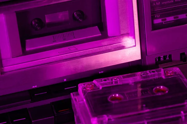 80年代的老式便携式立体声盒式盒式磁带录音机 盒式磁带小巧 可反射粉红霓虹灯 — 图库照片