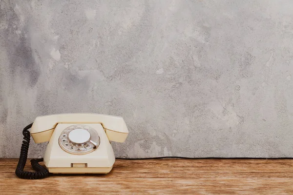Vintage Amarelo Telefone Discagem Rotativa Mesa Madeira Frente Fundo Concreto — Fotografia de Stock