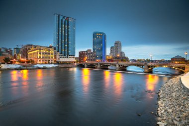 Grand Rapids, Michigan, USA downtown skyline on the Grand River at dusk. clipart
