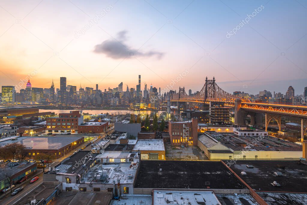 Queens, New York, USA view with the Queensboro Bridge towards Manhattan at dusk.