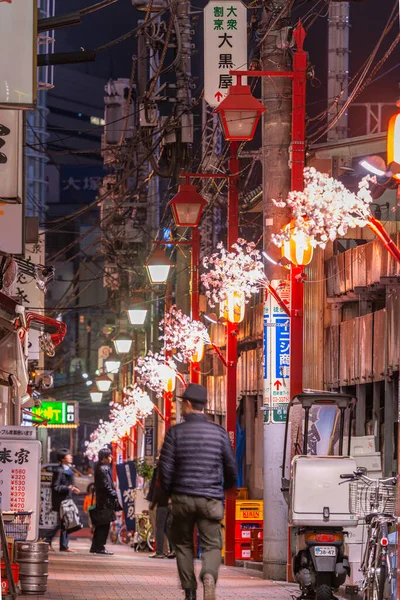 日本东京 2014年3月20日 一名行人带着装饰的春光饰品穿过新宿的一条小巷 — 图库照片