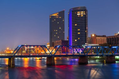 Grand Rapids, Michigan, USA downtown skyline on the Grand River at dusk. clipart