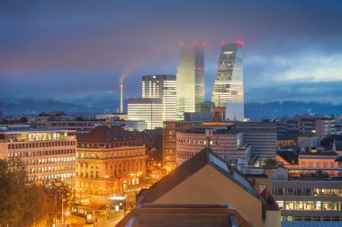 Alacakaranlıkta finans binaları olan İsviçre, Basel şehri.