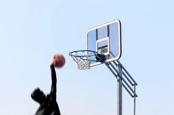 Athlete throwing ball into basket — Stock Photo, Image