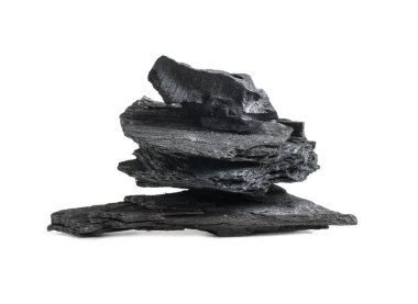 Siyah kömür parçaları beyaz arka planda izole bir şekilde birbirlerinin üzerinde uzanıyorlar.