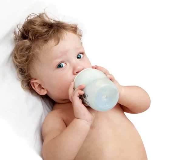 Little curly-headed baby sucks milk — Stock Photo, Image