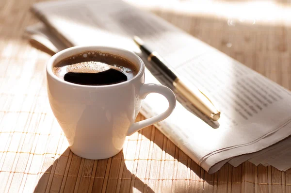 Cup of coffee, newspaper and a pen — Stock Photo, Image