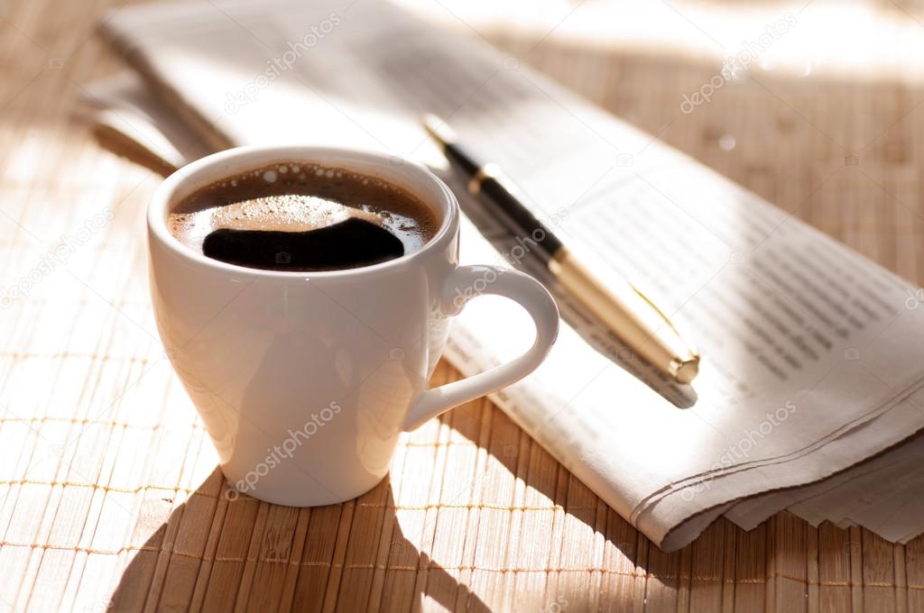 Cup of coffee, newspaper and a pen