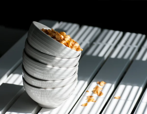 Flocos de milho em uma tigela na mesa — Fotografia de Stock