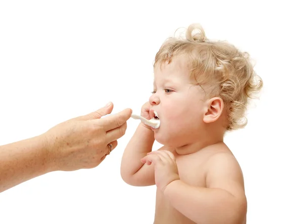 Mother feeds baby with spoon Stock Photo