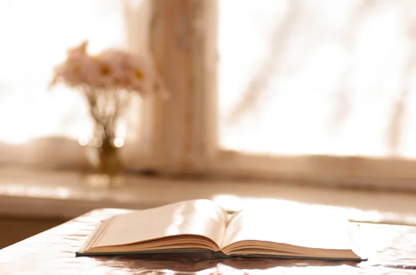 Boek op tafel in de buurt van venster — Stockfoto