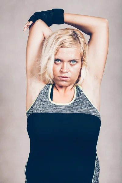 Mujer deportiva seria estirando los brazos — Foto de Stock