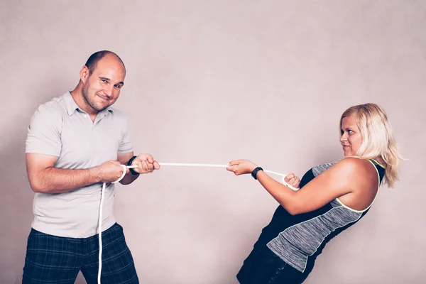 Homem e mulher confiantes puxando uma corda — Fotografia de Stock