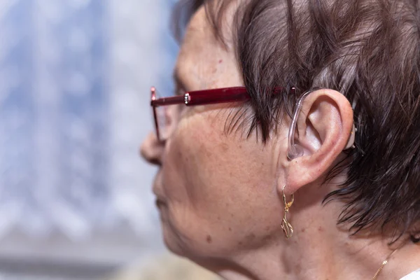 ผู้หญิงอาวุโสที่มีความช่วยเหลือหูหนวก — ภาพถ่ายสต็อก