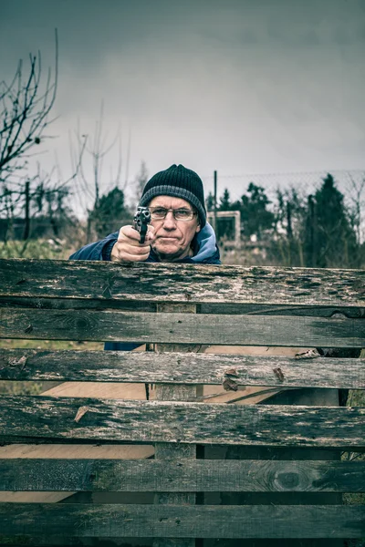 Senior man die een pistool richt — Stockfoto