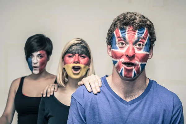 Excited people with European flags on faces — Stock Photo, Image