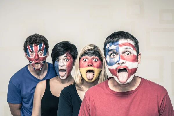 Grappige mensen met vlaggen op gezichten — Stockfoto