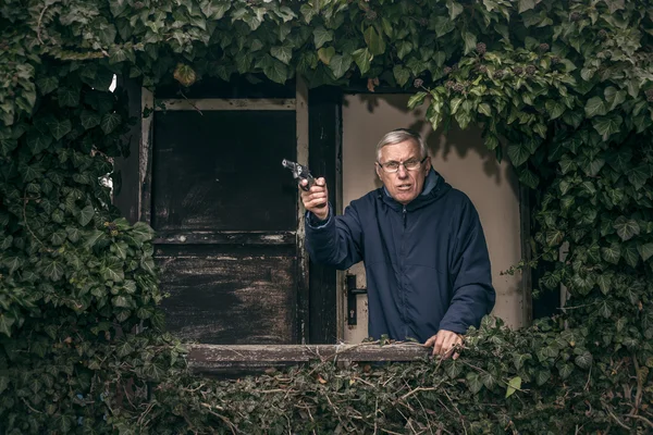 Senior man met een pistool bescherming van eigendom — Stockfoto