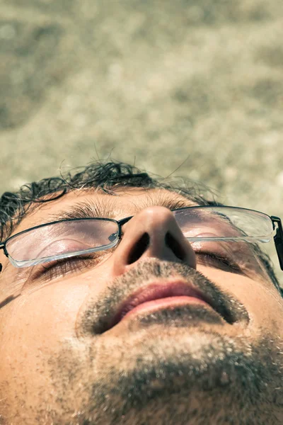 Крупный план человека, спящего на пляже — стоковое фото