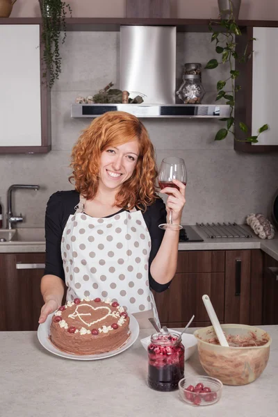 Щаслива жінка в коханні показує домашній торт — стокове фото