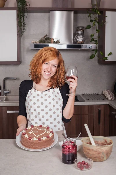 Glückliche verliebte Frau zeigt selbstgebackenen Kuchen Stockfoto