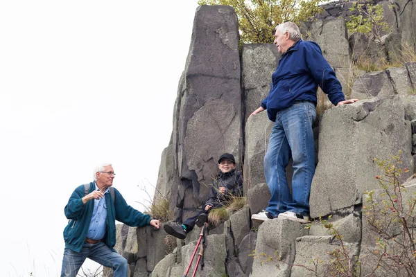 高齢者と子の岩の上のトレッキング — ストック写真