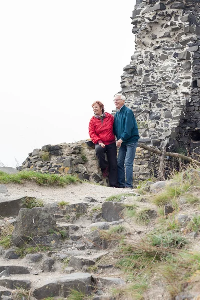 Glückliches Seniorenpaar wandert in felsigem Gelände lizenzfreie Stockfotos