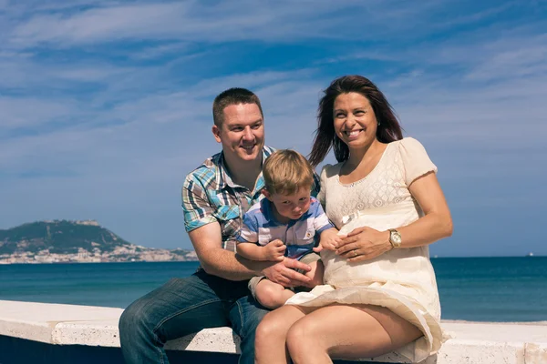 Feliz pareja embarazada y niño en la costa —  Fotos de Stock