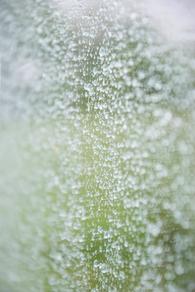 Gotas de água naturais em vidro de janela com verde — Fotografia de Stock