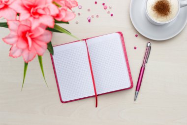 Defter ile fincan kahve ve ahşap çiçek 