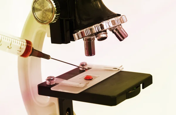 Foto de una muestra blanda en una diapositiva del microscopio con una jeringa —  Fotos de Stock