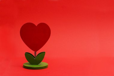 Kırmızı bir arka plan üzerinde kalp şeklinde ağaç 
