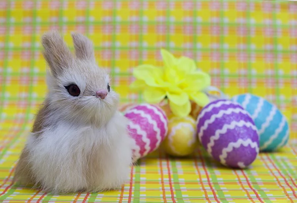 Conejo de Pascua sobre un fondo de huevos coloridos — Foto de Stock