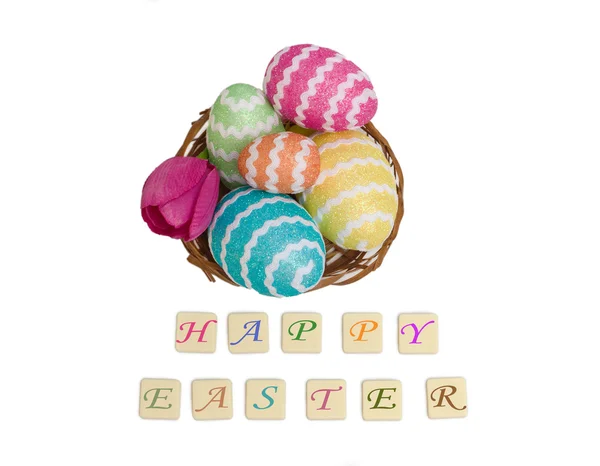 Uova di Pasqua in un cesto con auguri felici su bianco — Foto Stock
