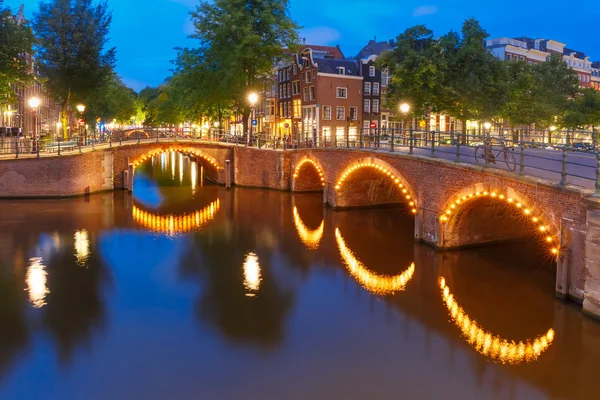 Night city view of Amsterdam canal and bridge — Stock Photo, Image