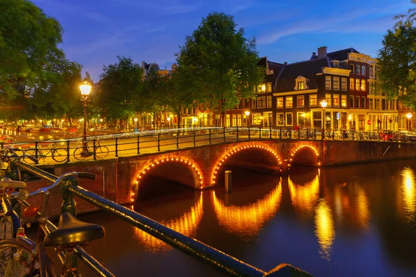 Noční město pohled na amsterdamském kanále a most — Stock fotografie
