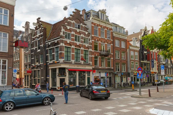 Mensen en auto's op een typische kruispunt in Amsterdam — Stockfoto