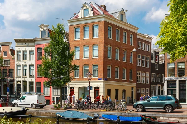 Cyclistes et voiture à un carrefour typique d'Amsterdam — Photo