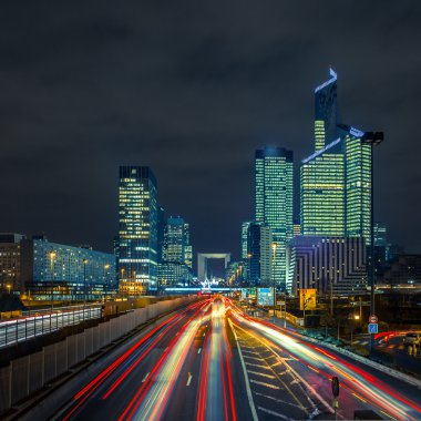 Night road with skyscrapers of La Defense, Paris, France. clipart