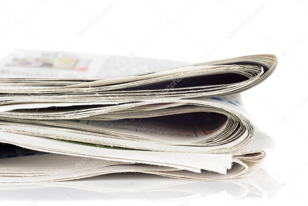 A close up of a pile of newspapers on a white background