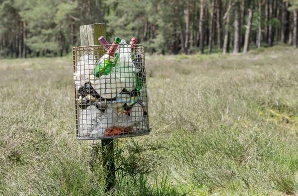 ドイツ ニーダーザクセンエイプリル20 2021 テキストのコピースペースがある田舎の木のポストにゴミがいっぱいの金属製のゴミ箱 — ストック写真